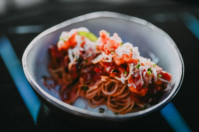 a white bowl filled with lots of food on top of a table